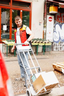 Bir adam bir şey düşürmemek için arabaya dikkatlice baktı. Teslimata gidiyor. Yüksek kalite fotoğraf
