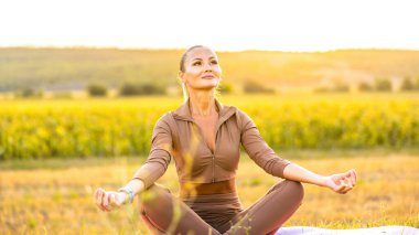Sonbaharda dua pozisyonunda yoga yapan kadın, sarı ve altın yapraklar ve yapraklarla çevrili. Yüksek kalite fotoğraf