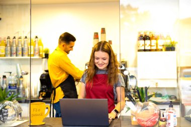 Barista Kahve Hazırlama Düzenli Çalışma Konsepti. Biri kahve hazırlar, diğeri bilgisayarla mutlu bir şekilde çalışır. Yüksek kalite fotoğraf