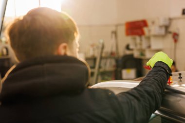 Tamirci, çatısı dolu yüzünden hasar gören bir araba üzerinde çalışıyor, çatıya çam ağacı yerleştiriyor. Yüksek kalite fotoğraf