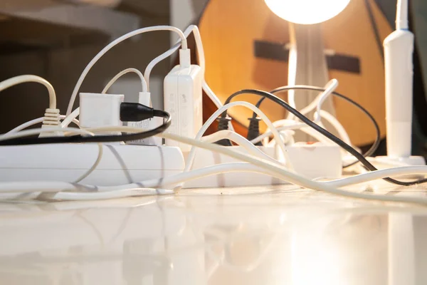 Elektrik uzatma kabloları ve bir anahtar. Birçok şarj aleti açık. Seçici odaklanma. Kavram.