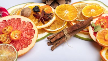 Kurutulmuş narenciye ve kırmızı limon dilimleri, portakal, tarçın, fındık, yıldız anason, greyfurt. Baharatlar sıcak şarap için.