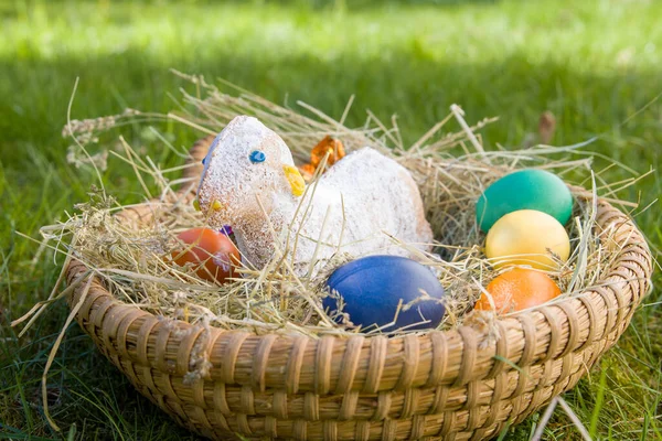 beautiful easter eggs and easter lamb in basket on the green grass. Selective focus.