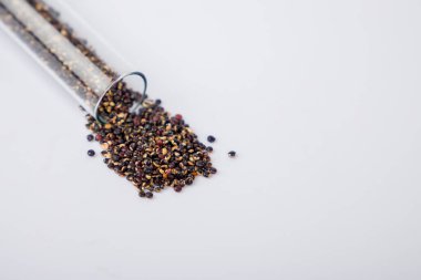 Cam test tüpündeki siyah kinoa tohumları, yakın plan, seçici odak.