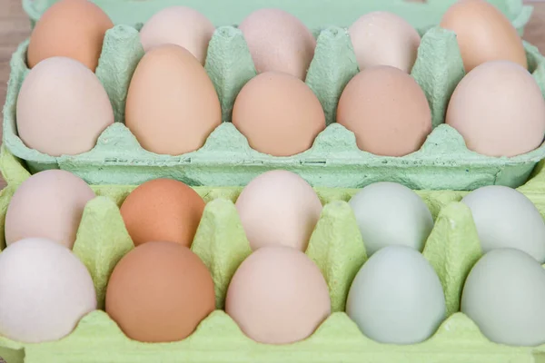 Different types of chicken eggs in carton . Selective focus.
