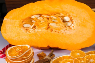 Beyaz arka planda turuncu dilimler ve tarçınlı balkabağı