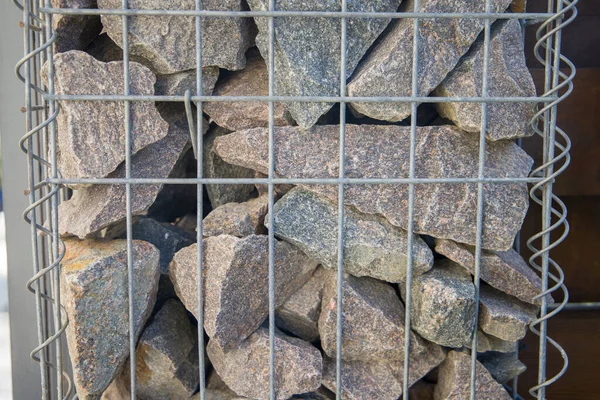 Stone wall with metal mesh as a background, closeup of photo