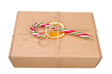 Beyaz arka planda izole edilmiş lolipop ve portakallı Noel hediyesi kutusu