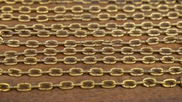 Tahta arka planda altın zincirli kolyeyi kapat. Seçici odak.