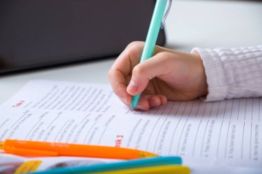 Evdeki deftere yazan bir çocuğun elini kapat.