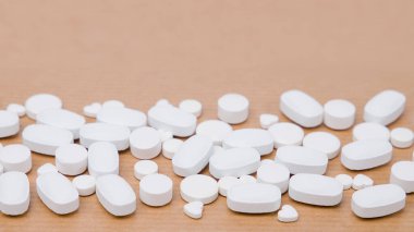 Kahverengi arka planda beyaz haplar.