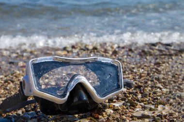 Çakıl taşı plajında şnorkel maskesi. Seçici odak.