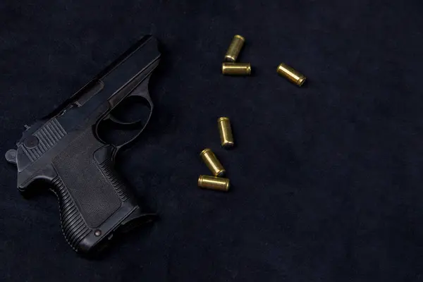 stock image 9mm pistol and bullets on a black leather background, top view