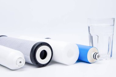 Beyaz arka planda su filtresi ve su bardağı. Seçici odak.