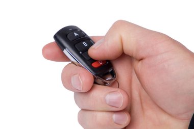 Uzaktan kumandayı tutan el beyazda izole edilmiş.