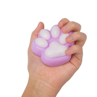 Pink toy cat paw in the hand isolated on a white background. Decompression squeeze toy. clipart