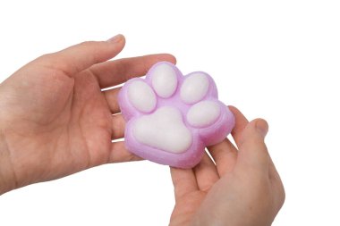 Pink toy cat paw in the hand isolated on a white background. Decompression squeeze toy. clipart