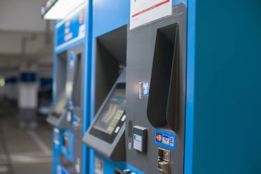 Bir kadın alışveriş merkezinde otomatik vezne makinesiyle park ücretini öder, manzarayı kapat