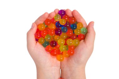 Elinde su renkli jel topları var. Beyazda izole edilmiş. Orbeez..