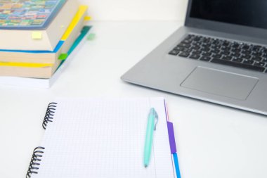 Masasında kalem ve dizüstü bilgisayar olan bir defter. Eğitim kavramı.
