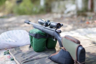 Askeri teçhizatın arka planında keskin nişancı tüfeği var. Seçici odak.