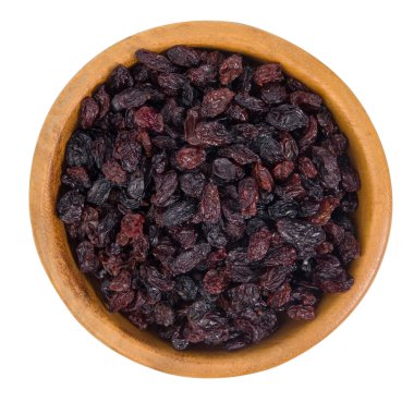 Siyah kuru üzümler beyaz arka planda izole edilmiş ahşap bir kasede.