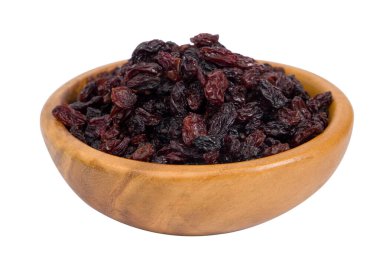 Beyaz arka planda izole edilmiş ahşap bir kasede kurumuş kuru üzümler..