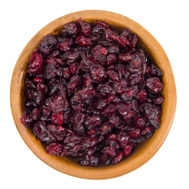 Beyaz arka planda izole edilmiş ahşap bir kasede kurumuş yaban mersini. Üst görünüm.