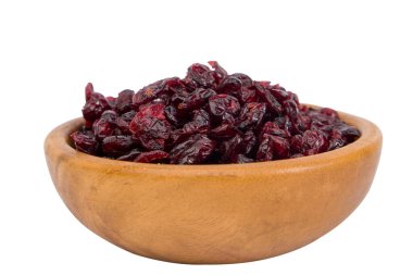 Beyaz arka planda izole edilmiş ahşap bir kasede kurumuş yaban mersini. Seçici odak.