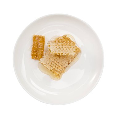 Beyaz tabakta bal peteği. Beyaz bir arka planda izole edilmiş. Üst görünüm.