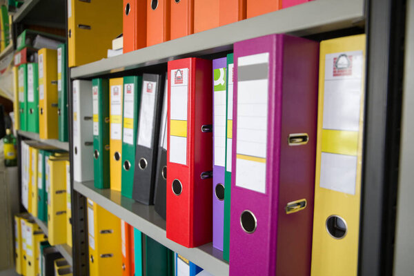 Office folders with documents on shelves in the office. Business concept.