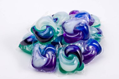 Bir yığın yeşil, mor, mavi ve beyaz çamaşır jeli kapsülü.