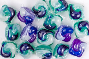 Yeşil, mor, mavi ve beyaz renkte çamaşır jeli kapsüllerin arka planı.