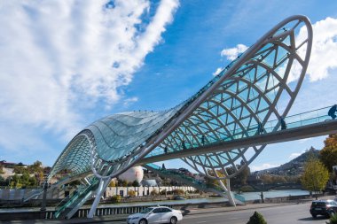 Tiflis, GEORGIA: 05 - 10 - 2022: Barış Köprüsü, Gürcistan 'ın eski Tiflis kentindeki Kura Nehri üzerindeki modern yay şeklinde yaya köprüsü.