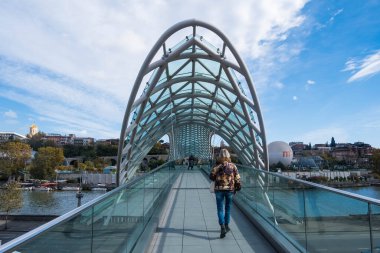 Tiflis, GEORGIA: 05 - 10 - 2022: Barış Köprüsü, Gürcistan 'ın eski Tiflis kentindeki Kura Nehri üzerindeki modern yay şeklinde yaya köprüsü.