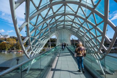 Tiflis, GEORGIA: 05 - 10 - 2022: Barış Köprüsü, Gürcistan 'ın eski Tiflis kentindeki Kura Nehri üzerindeki modern yay şeklinde yaya köprüsü.