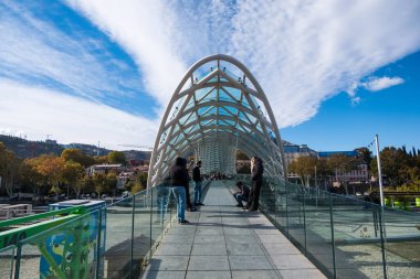 Tiflis, GEORGIA: 05 - 10 - 2022: Barış Köprüsü, Gürcistan 'ın eski Tiflis kentindeki Kura Nehri üzerindeki modern yay şeklinde yaya köprüsü.