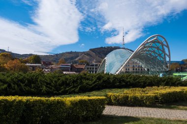 Tiflis, GEORGIA: 05 - 10 - 2022: Barış Köprüsü, Gürcistan 'ın eski Tiflis kentindeki Kura Nehri üzerindeki modern yay şeklinde yaya köprüsü.