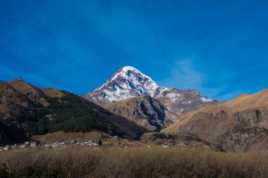 Kazbegi, Georgia : 10-11-2022 : Aerial view of Stepantsminda Kazbegi, Georgia, Panoramic landscape of beautiful natural mountains view of beautiful Caucasus mountain peaks and meadow.