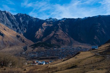 Kazbegi, Georgia : 10-11-2022 : Aerial view of Stepantsminda Kazbegi, Georgia, Panoramic landscape of beautiful natural mountains view of beautiful Caucasus mountain peaks and meadow