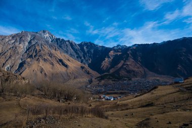 Kazbegi, Georgia : 10-11-2022 : Aerial view of Stepantsminda Kazbegi, Georgia, Panoramic landscape of beautiful natural mountains view of beautiful Caucasus mountain peaks and meadow