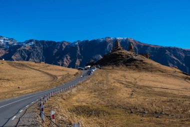 Kazbegi, Georgia : 10-11-2022 : amazing panorama of ancient Gergeti Trinity Church and glorious Caucasus mountains, Panoramic landscape of beautiful natural mountains  peaks and meadow, Kazbegi, Georgia