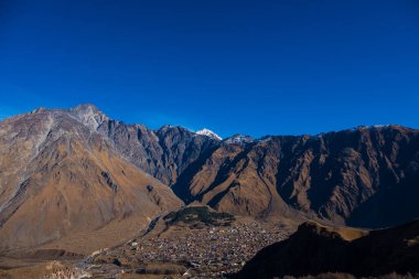 Kazbegi, Georgia : 10-11-2022 : Aerial view of Stepantsminda Kazbegi, Georgia, Panoramic landscape of beautiful natural mountains view of beautiful Caucasus mountain peaks and meadow