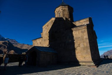 Kazbegi, Georgia : 10-11-2022 : close up of ancient Gergeti Trinity Church and glorious Caucasus mountains around