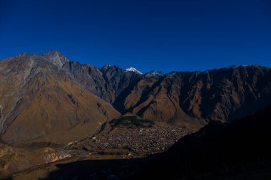 Kazbegi, Georgia : 10-11-2022 : Aerial view of Stepantsminda Kazbegi, Georgia, Panoramic landscape of beautiful natural mountains view of beautiful Caucasus mountain peaks and meadow
