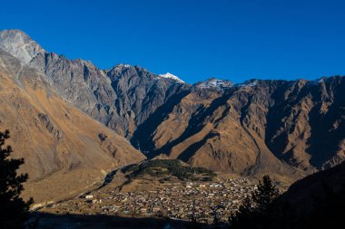 Kazbegi, Georgia : 10-11-2022 : Aerial view of Stepantsminda Kazbegi, Georgia, Panoramic landscape of beautiful natural mountains view of beautiful Caucasus mountain peaks and meadow
