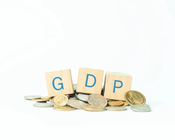 stock image Word GDP written on toy blocks and coins on table with white background