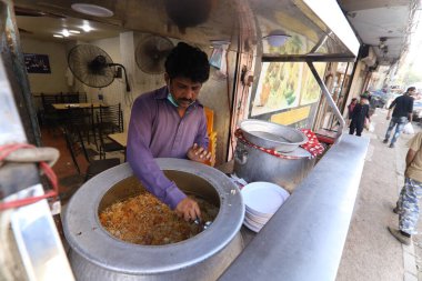 Burns Yolu Mart 2021, Karaçi 'nin ünlü ve eski yemek caddelerinde biryani satan genç bir adam, Karaçi' nin lokantalarında....