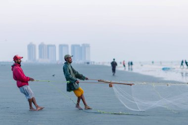 Karachi Pakistan 2021, balık yakalamak için balıkçı ağı çeken bir balıkçı, akşam vakti deniz manzaralı..