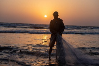 Karachi Pakistan 2021, balık yakalamak için balıkçı ağı çeken bir balıkçı, akşam vakti deniz manzaralı..